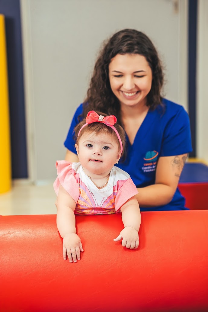 Fisioterapeuta acompanhando bebê em atividade do Conceito Neuroevolutivo Bobath